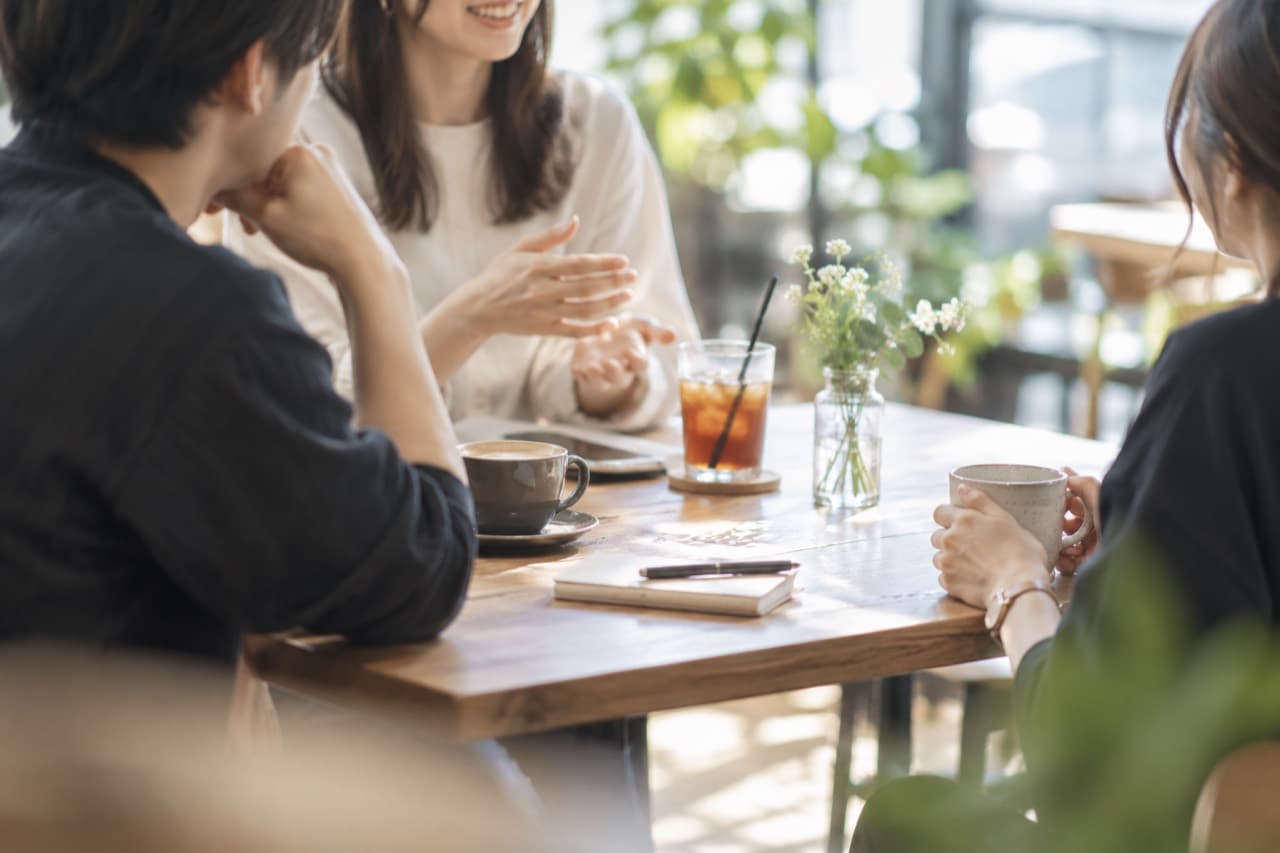 カフェのテーブルで会話する人たち